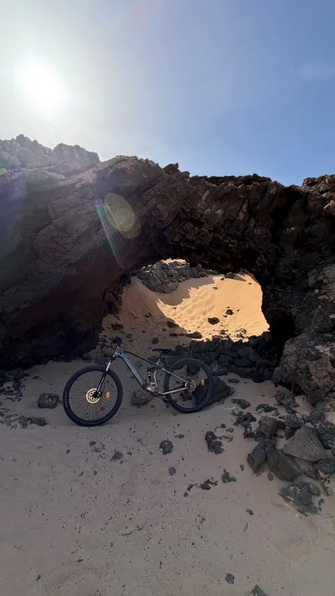 Bicicleta eléctrica entre roca volcánica y arena